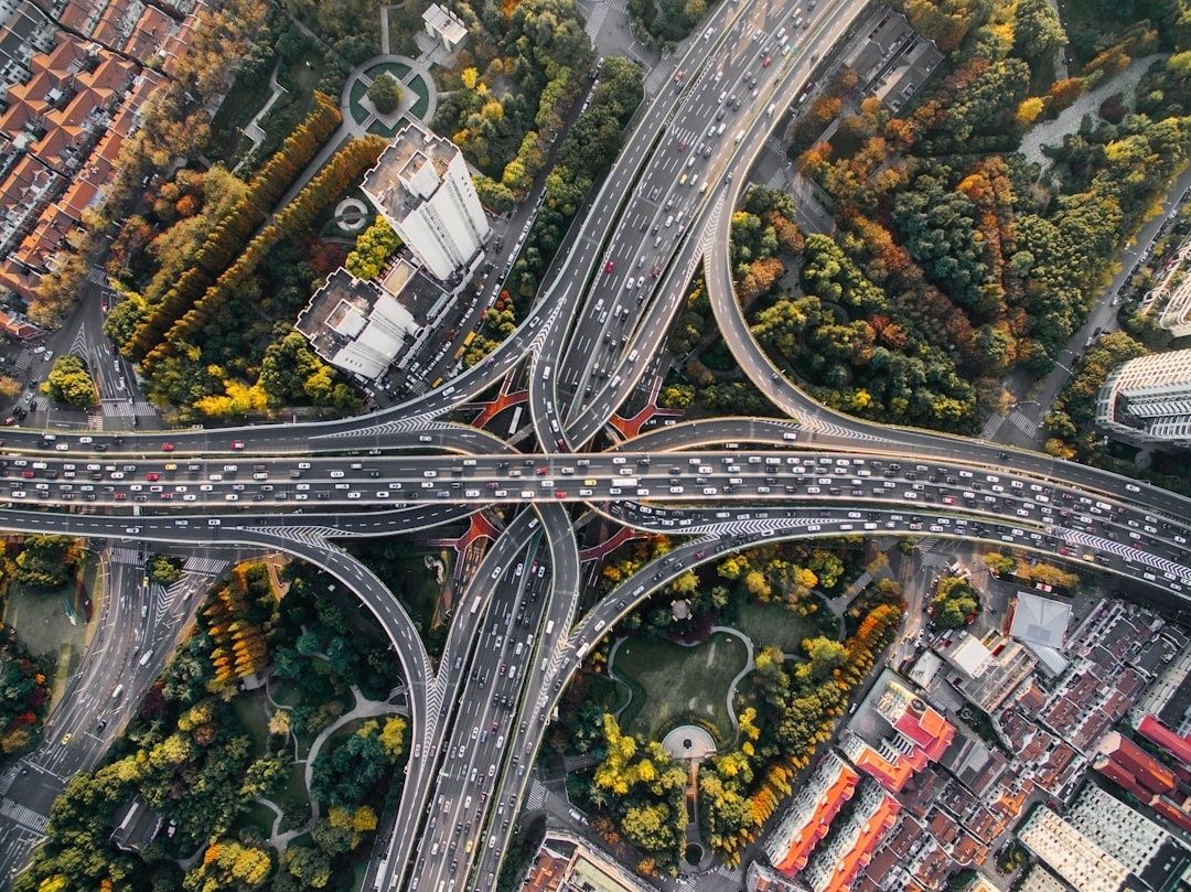 Flygbild över ett stort motorvägskors med trafik och parker