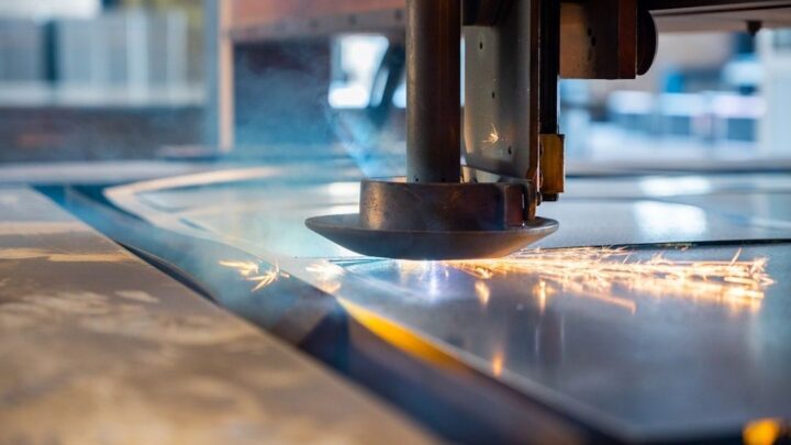 Industriellt skärhuvud skär i en blank metallskiva med gnistor