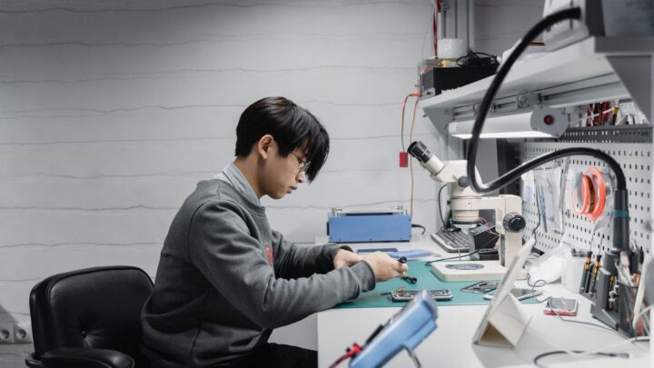Ung ingenjör arbetar med elektronik vid en laboratoriearbetsplats